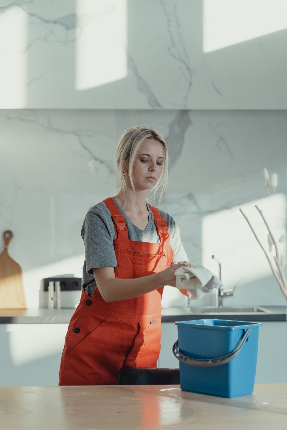 Cleaner wiping a modern kitchen surface