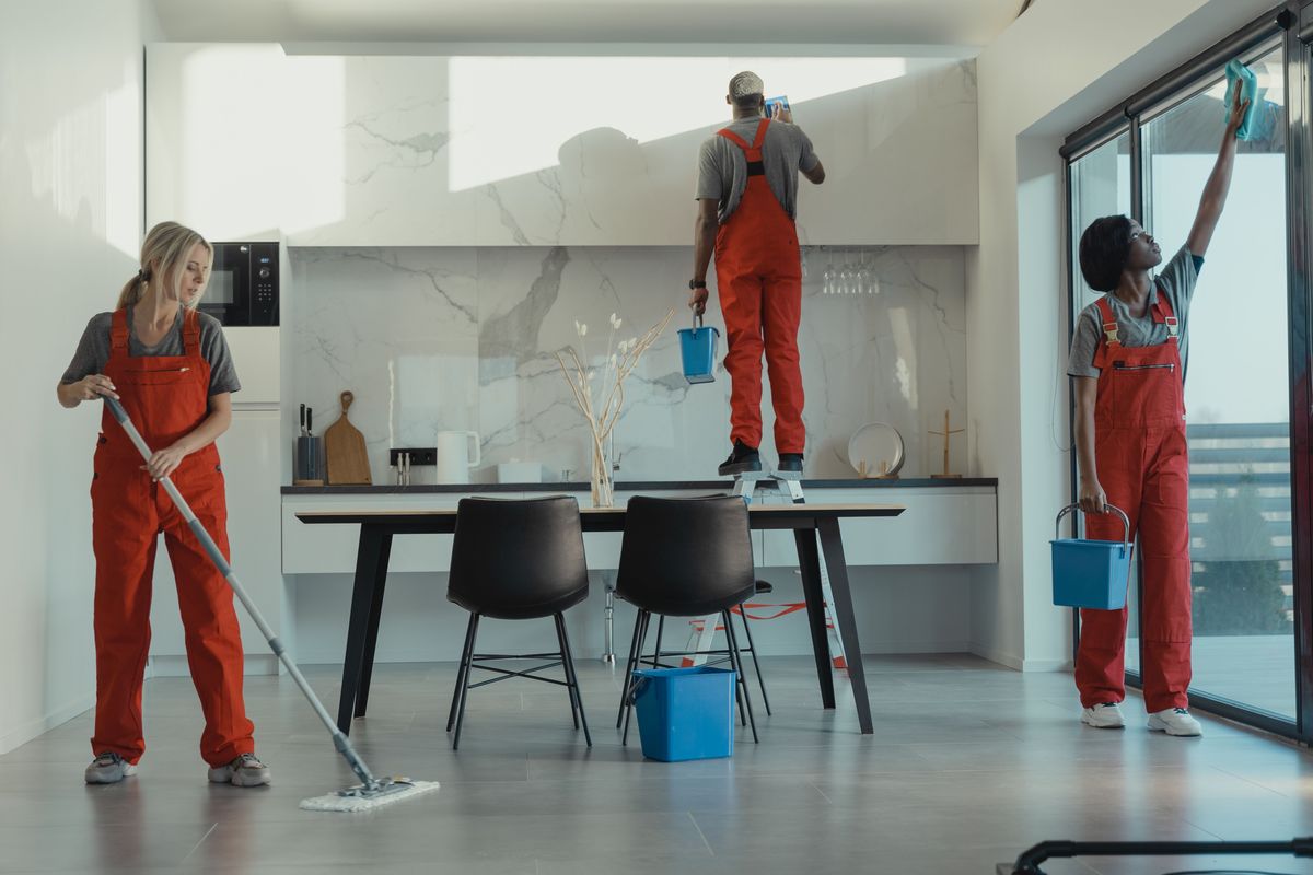 Professional cleaning team working throughout a modern room