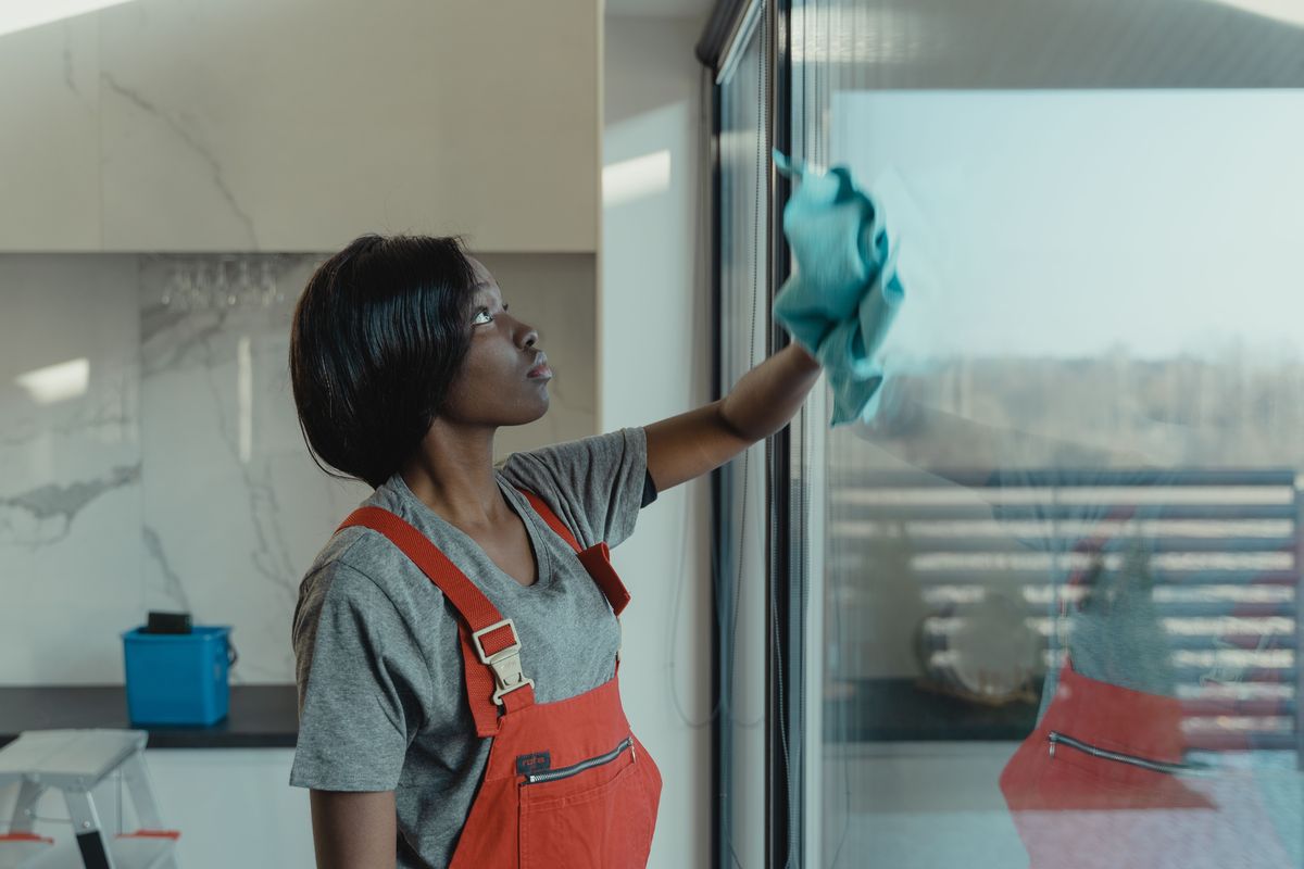 Professional cleaner washing a large window